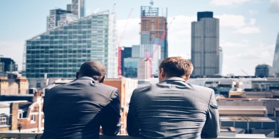 Two businessmen looking at city scape