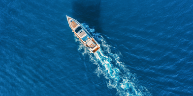Yacht at the sea in Europe. Aerial view of luxury floating ship at sunset. Colorful landscape with boat in marina bay, blue sea. Top view from drone of yacht. Luxury cruise. Seascape with motorboat.